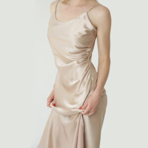 Woman in beige silk satin camisole dress, studio shot.